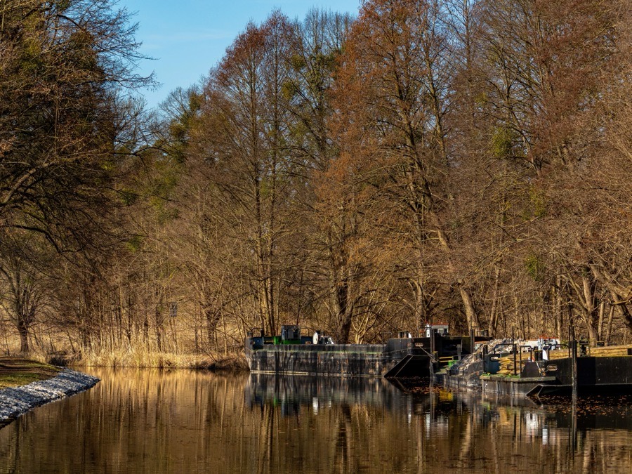 Construction barges tied up along a channel in early spring