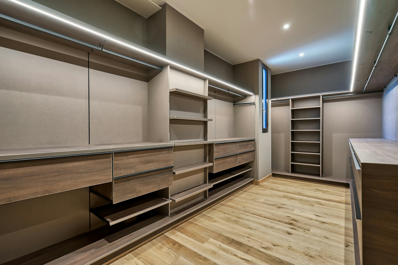 Custom walk-in closet in dark stained oak with integrated lighting
