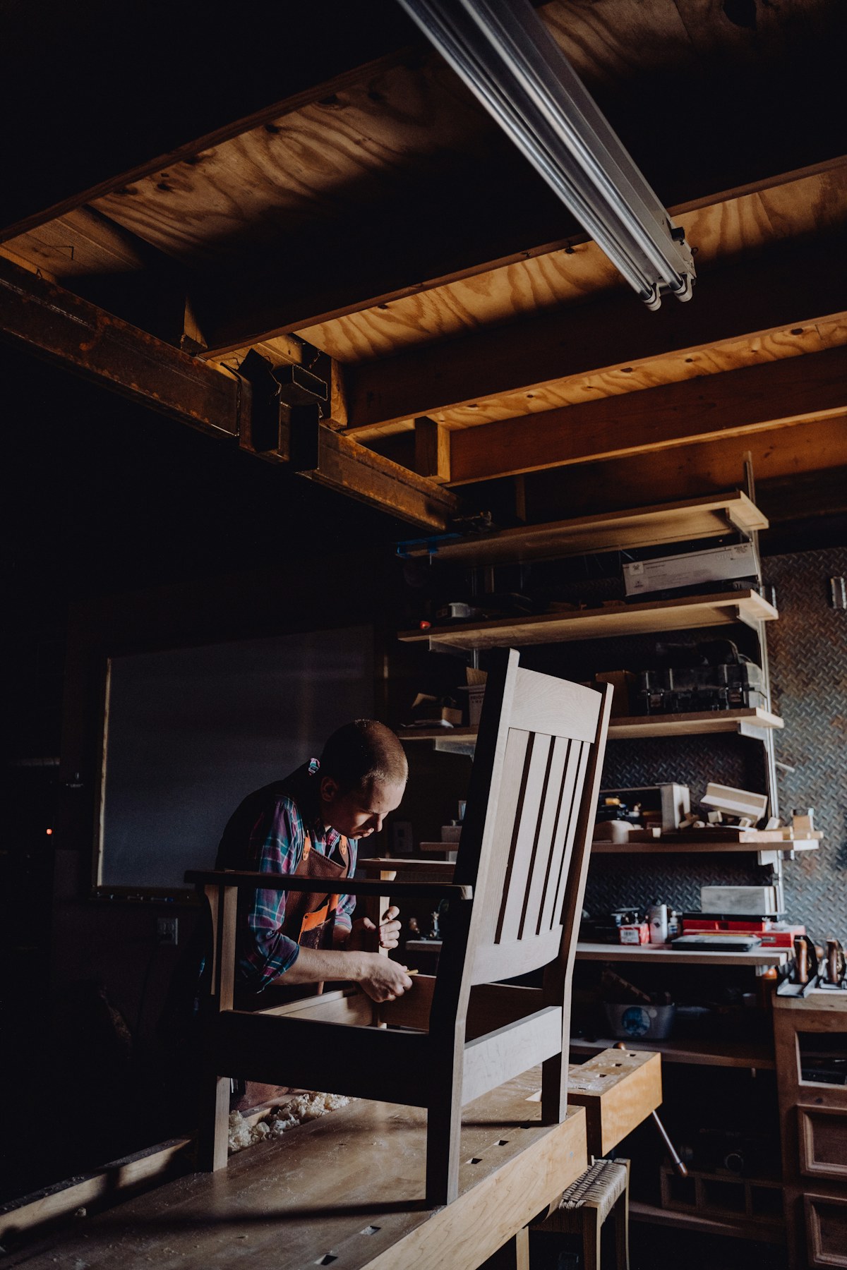 Craftsman shaping a chair in the workshop