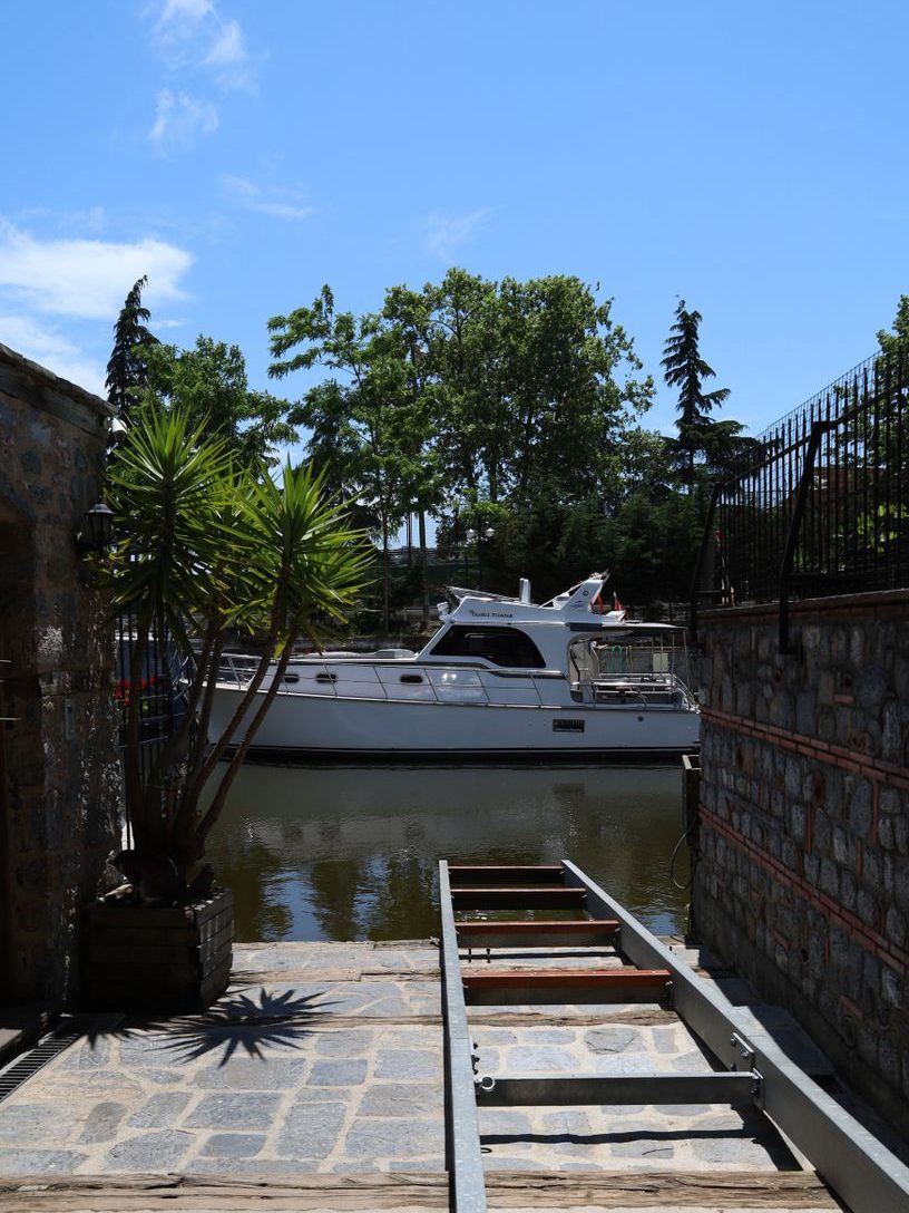 Boat lift rails running down into the water beside a paved waterfront terrace