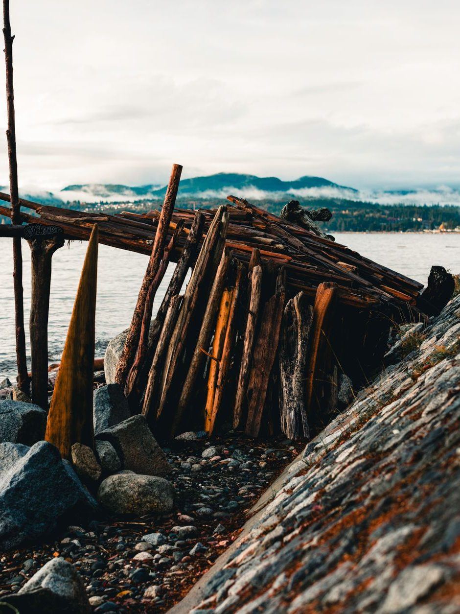 Timber crib bulkhead with rock riprap piled against its face along a stony shoreline