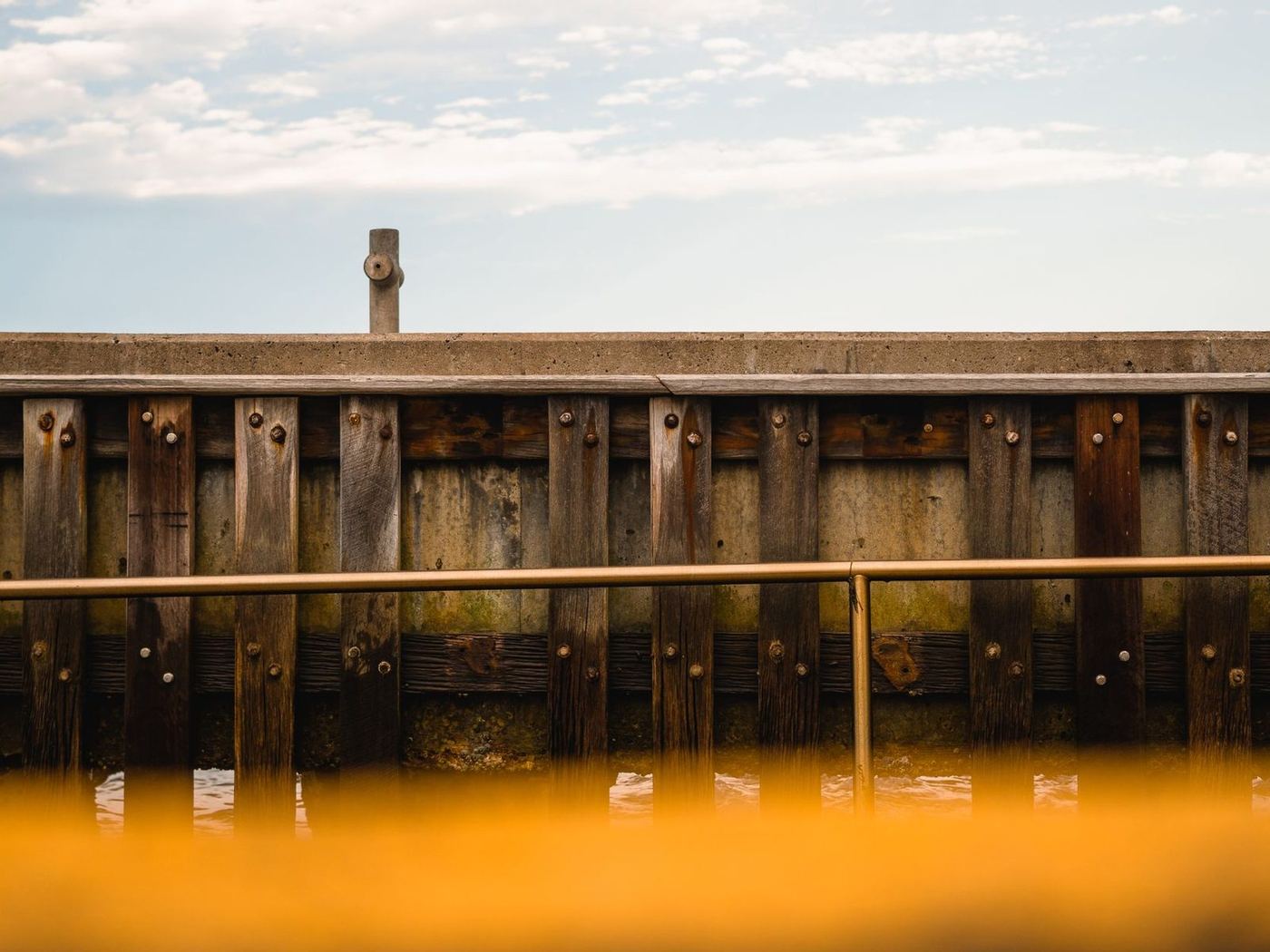 Timber bulkhead wall of stacked planks holding a bank back from the water
