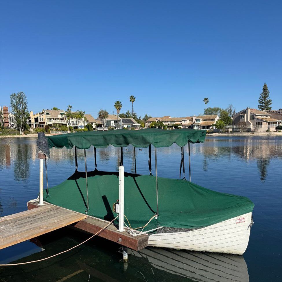 Small covered boat slip with a canopy over a moored boat on a still lake