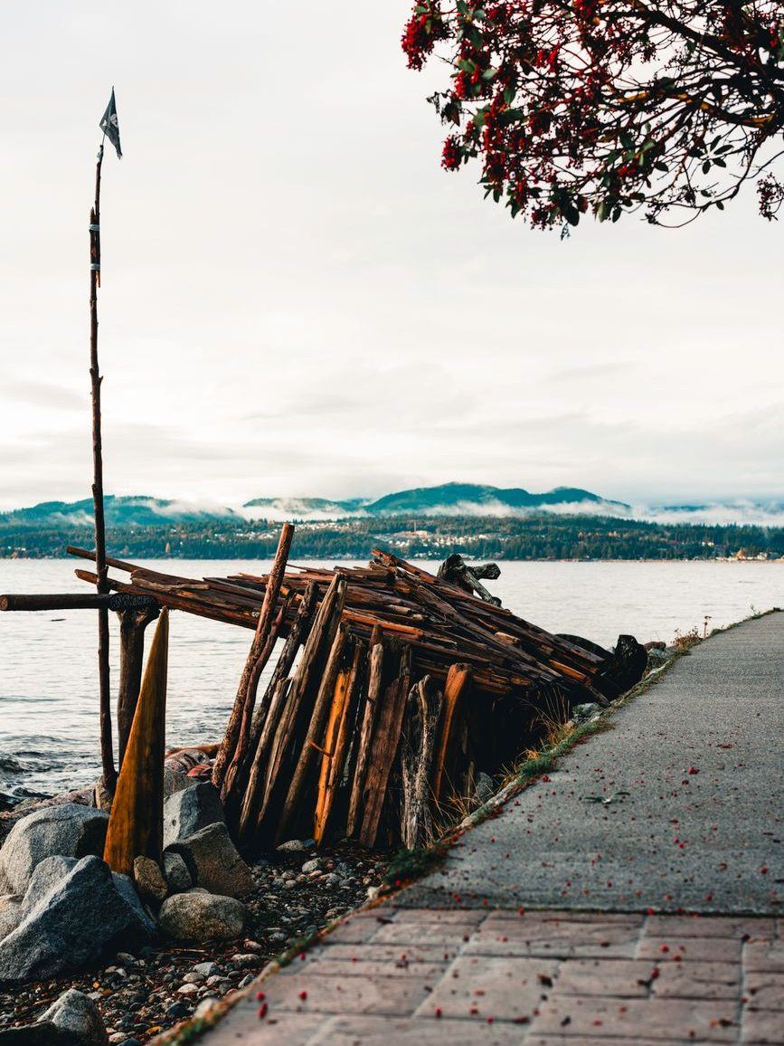 Timber crib seawall and rock armour running along a paved waterfront walkway