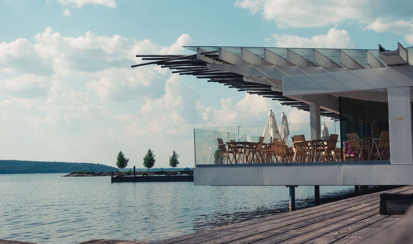 Modern waterfront deck with a cantilevered canopy and seating looking out over the water