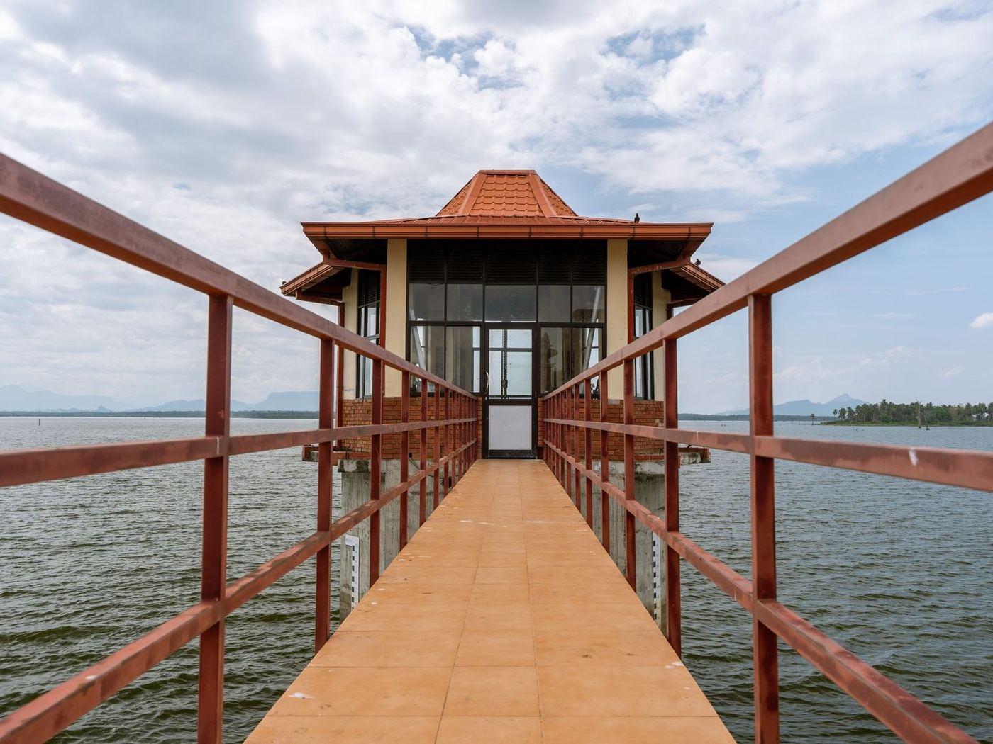 Timber pier running out to a small roofed pavilion standing over open water